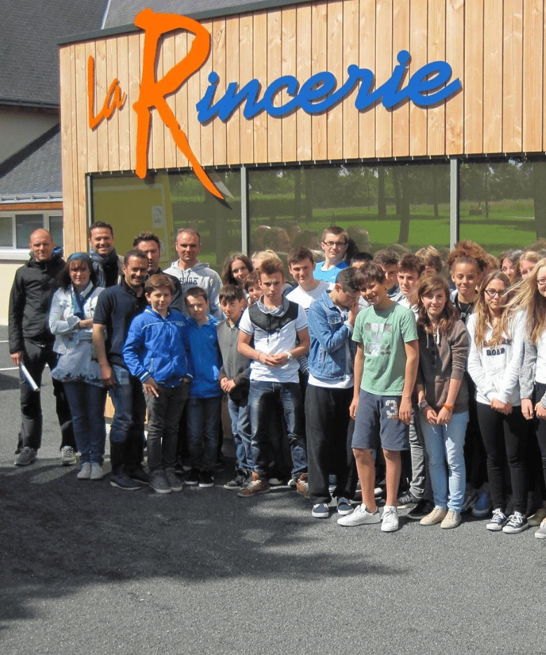Groupe de jeunes et d'accompagnateurs devant le bâtiment principal de la base de loisirs La Rincerie, en Mayenne.